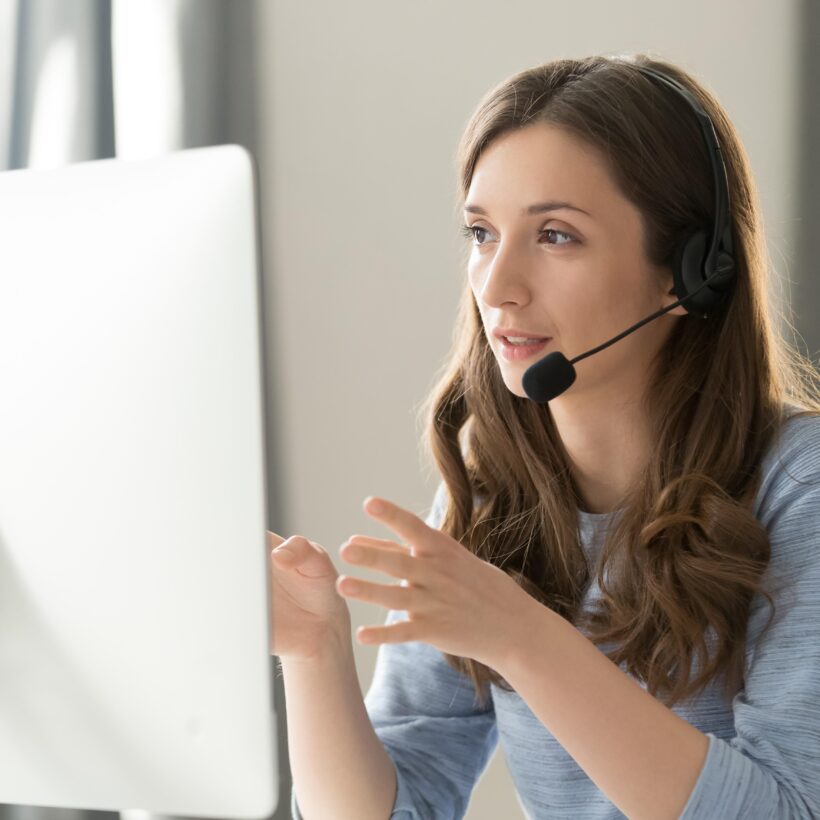 A woman in a headset, conversing on the phone, illustrating her role in customer service or telecommunication.