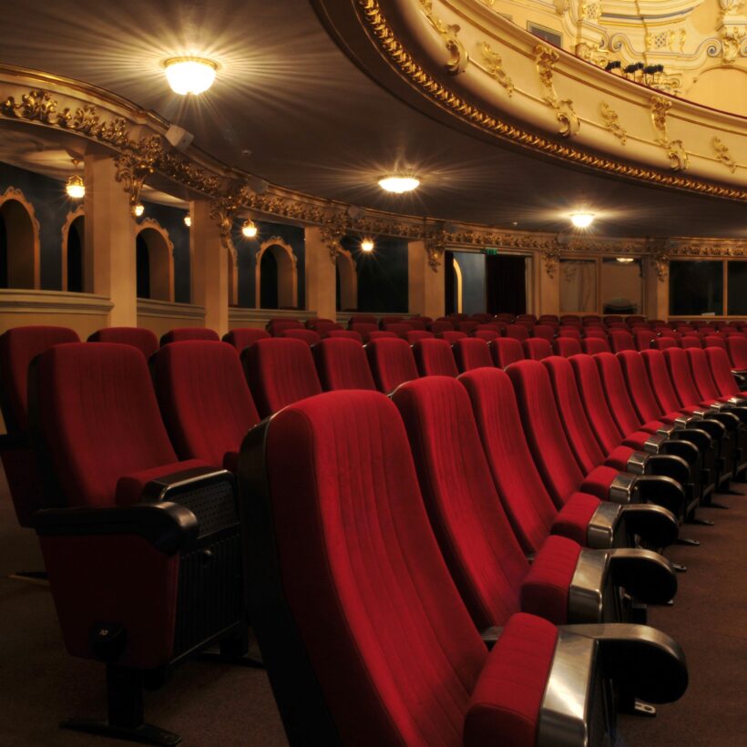 A close-up view of red seats, showcasing their bold colour and inviting appearance in a theatre