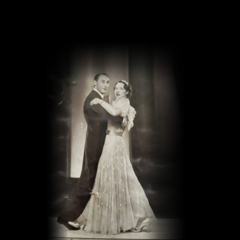 A man and woman in elegant formal attire gracefully dancing together on a polished floor.