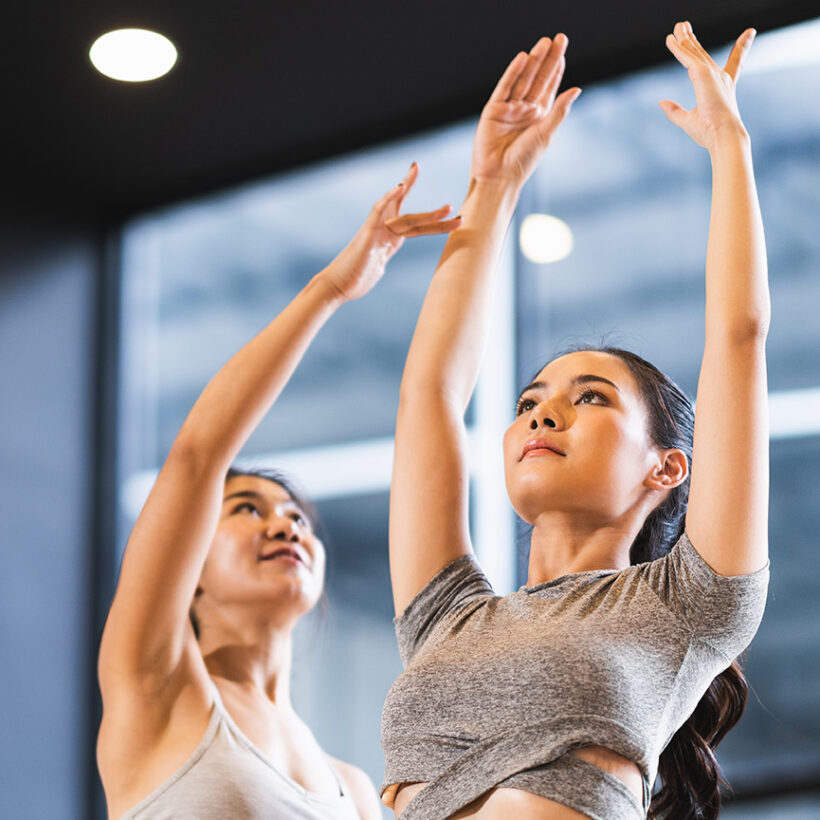 Two women practicing exercises in a dance studio, demonstrating their skills and enthusiasm for dance